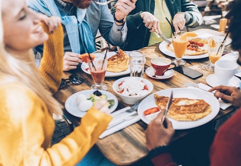 Multi ethnic group of friends eating lunch in a restaurant
