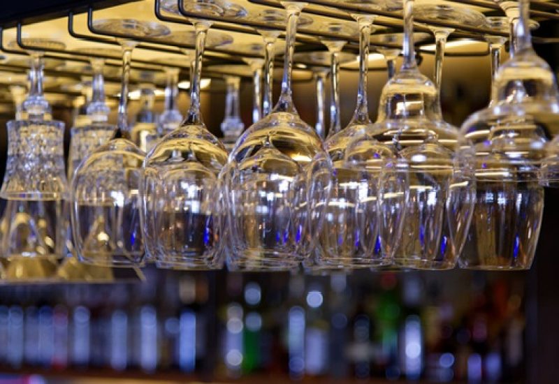 Group of empty wine glasses hanging in a bar