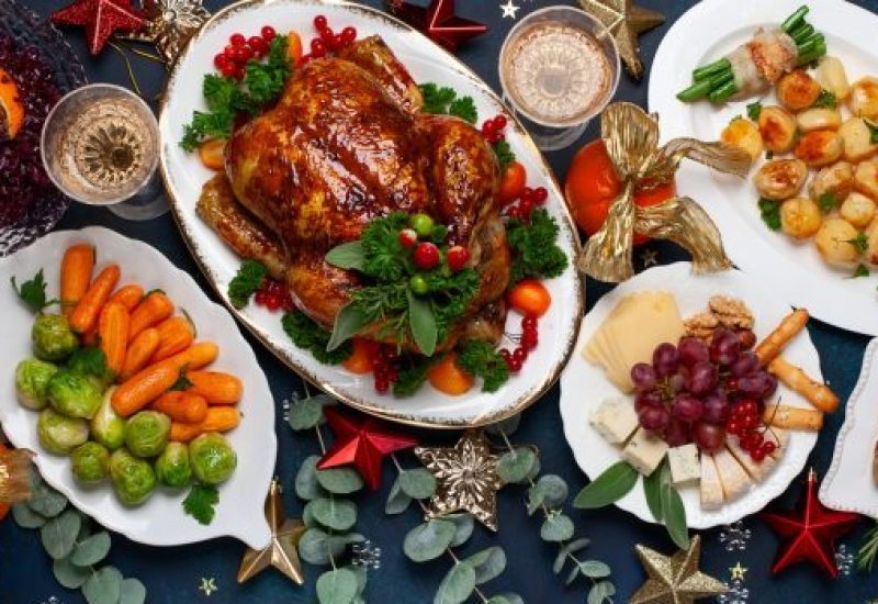 Concept of Christmas or New Year dinner with roasted chicken and various vegetables dishes.
