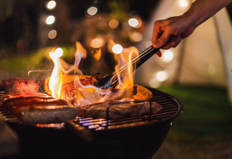 Family making barbecue in dinner party camping at night
