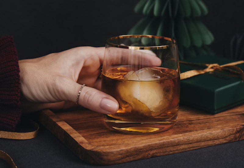 Woman drinking drink brandy whiskey or rum on ice Christmas feeling