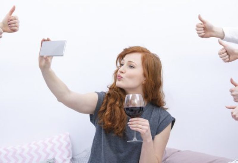 Woman taking selfie on bed