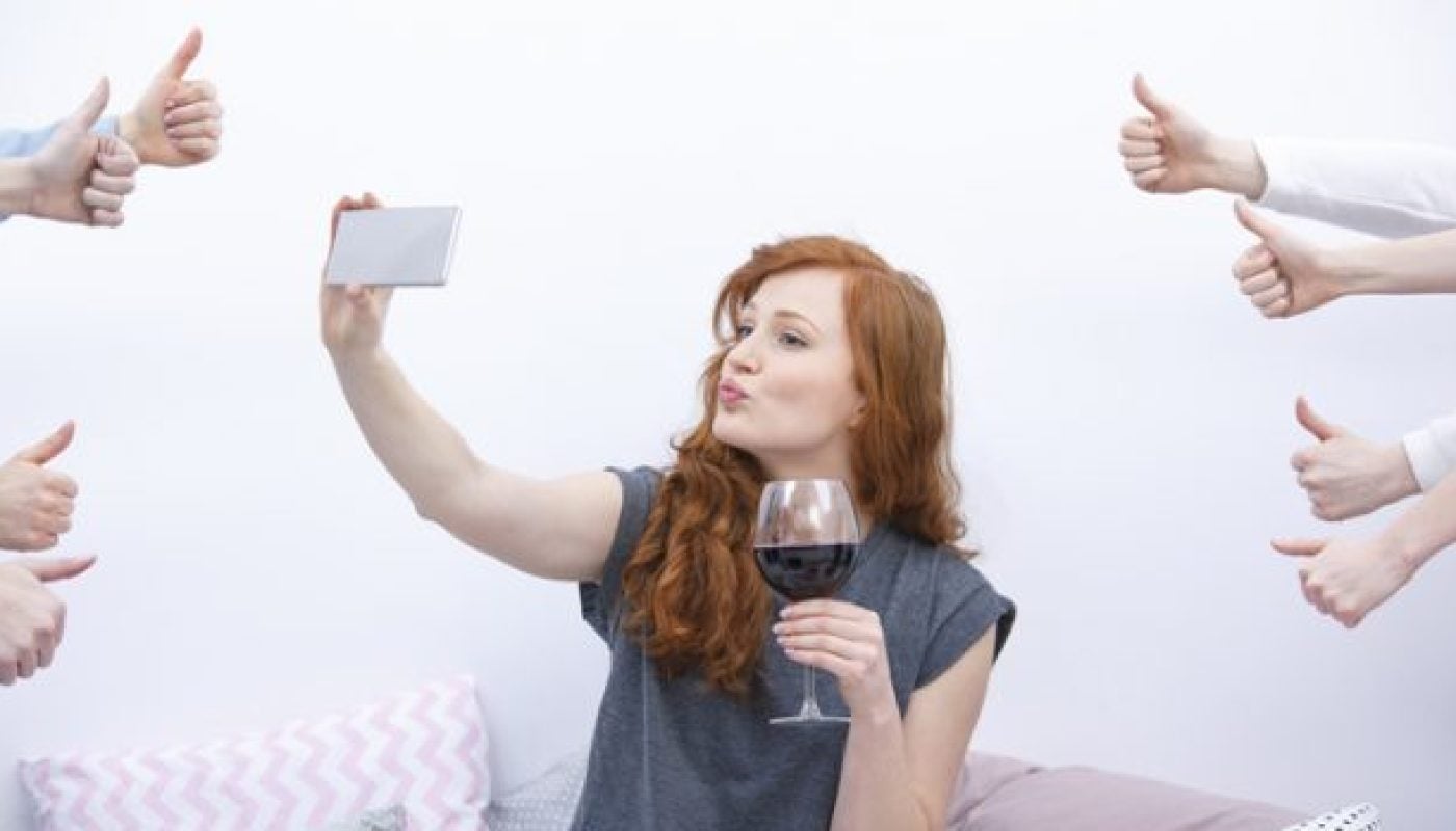 Woman taking selfie on bed