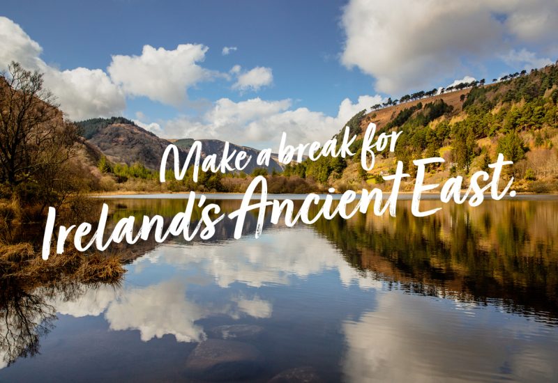 Dramatic landscape from the heart of Glendalough valley with the mountains and clouds reflecting in the water of the Lower lake. Irish Scenery. Blue sky. Wicklow National Park, Ireland
