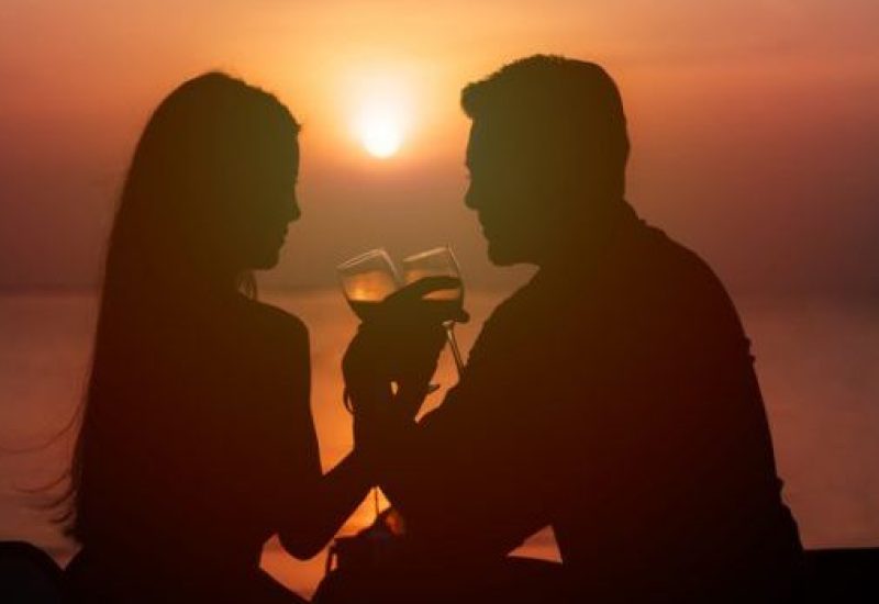 Silhouette of couple in love drinking wine during romantic dinner