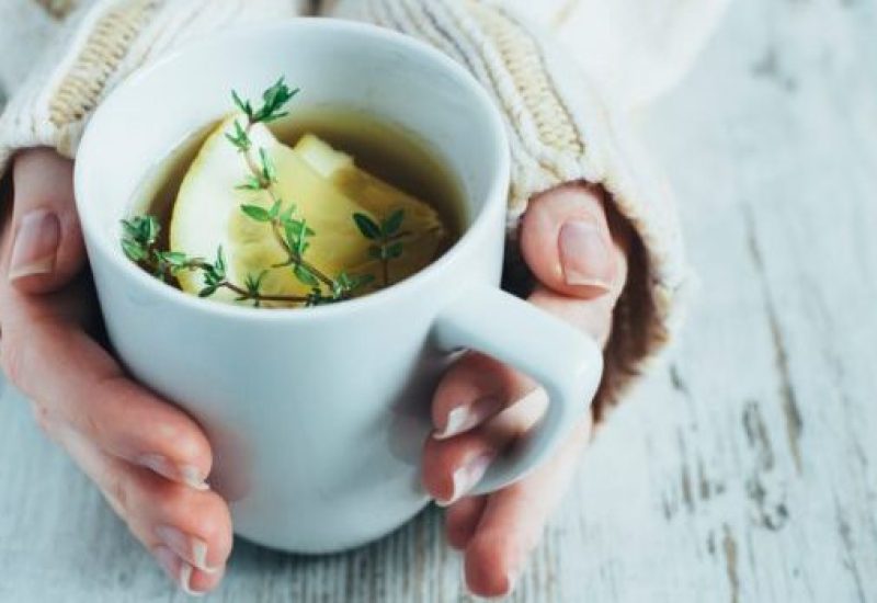 Cup of tea with thyme herb and lemon slices