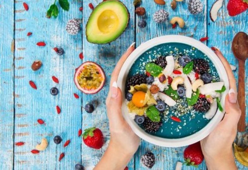 Smoothie bowl with fresh berries, nuts, seeds, fruit and vegetables