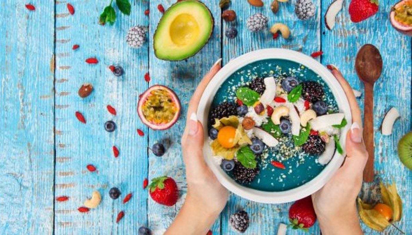 Smoothie bowl with fresh berries, nuts, seeds, fruit and vegetables
