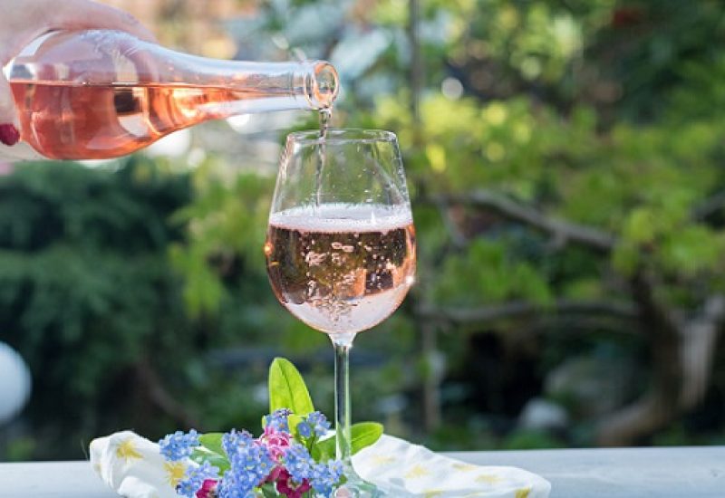 Waiter pouring a glas of cold rose wine, outdoor terrase, sunny day