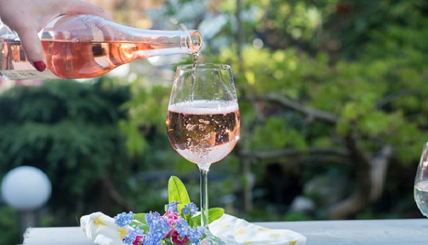 Waiter pouring a glas of cold rose wine, outdoor terrase, sunny day